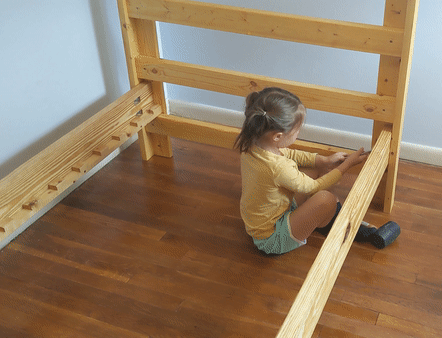 Daughter tightening bolts on bed frame